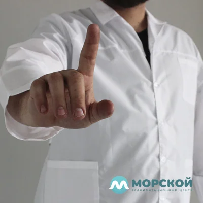врач в белом халате показывает жест пальцем